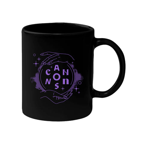 image of a black coffee mug on a white background. purple print on the front of the mug of two hards holding a crystal ball and the word CANNONS inside of the ball